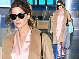 Kate Beckinsale looks sartorially chic in silky pantsuit and towering heels as she touches down at JFK