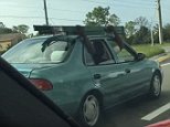 Florida man films two men holding a ladder on their car