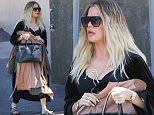 Khloe Kardashian conceals 'baby bump' by holding clothing