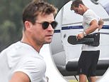 Chris Hemsworth straps on a support belt at the airport