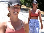 Kendra Wilkinson teases her flat abs in orange sports bra while hiking with a friend amid divorce