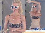Claudia Schiffer applies sunscreen in a leopard print bikini
